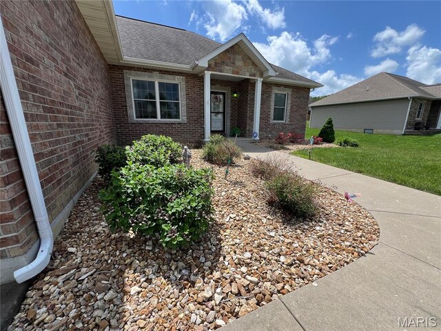 306 Traci Dawn Dr, Rolla, MO 65401 - view of front of home featuring roof with shingles, brick siding, and a front yard