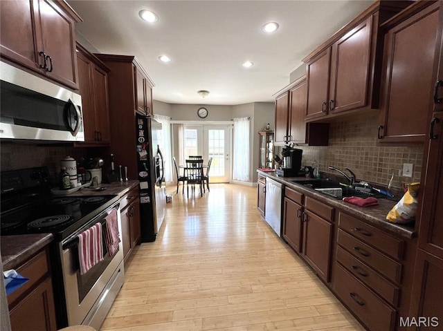 306 Traci Dawn Dr, Rolla, MO 65401 - kitchen with stainless steel appliances, dark countertops, backsplash, light wood finished floors, and recessed lighting