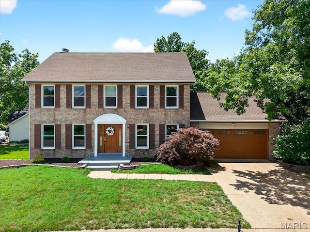 16544 Willow Glen Dr, Wildwood, MO 63040 - colonial inspired home with driveway, a front lawn, an attached garage, and brick siding