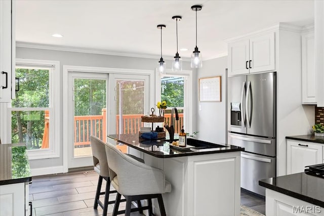 16544 Willow Glen Dr, Wildwood, MO 63040 - kitchen featuring stainless steel refrigerator with ice dispenser, dark countertops, white cabinets, crown molding, and a kitchen bar