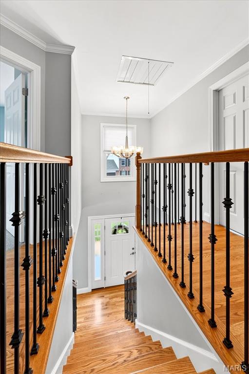 16544 Willow Glen Dr, Wildwood, MO 63040 - stairway featuring plenty of natural light, wood finished floors, a chandelier, ornamental molding, and attic access