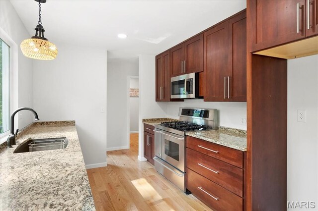 15371 Timber Hill Ln, Chesterfield, MO 63017 - kitchen with appliances with stainless steel finishes, light wood-style floors, light stone counters, pendant lighting, and recessed lighting