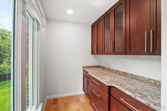 15371 Timber Hill Ln, Chesterfield, MO 63017 - kitchen with light wood-type flooring, light stone counters, glass insert cabinets, and recessed lighting