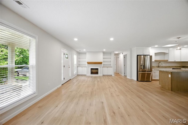6905 Scenic View Dr, Cedar Hill, MO 63016 - unfurnished living room featuring light wood-style flooring, a fireplace, recessed lighting, and built in shelves