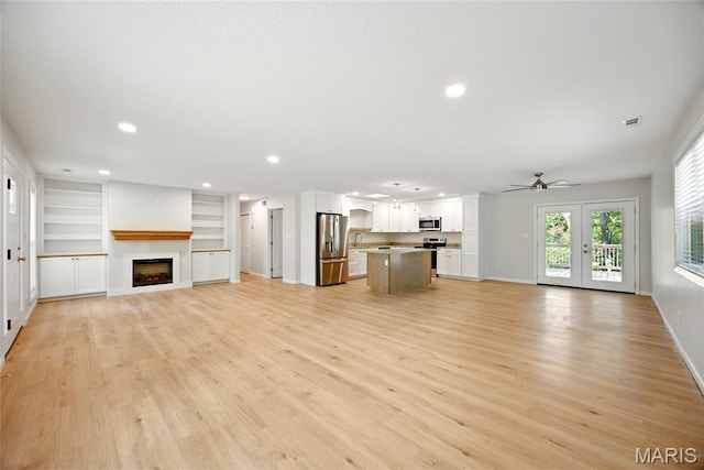 6905 Scenic View Dr, Cedar Hill, MO 63016 - unfurnished living room with ceiling fan, light wood-style flooring, a fireplace, recessed lighting, and built in shelves
