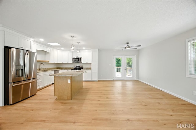 6905 Scenic View Dr, Cedar Hill, MO 63016 - kitchen featuring stainless steel appliances, a center island, light wood finished floors, white cabinets, and recessed lighting