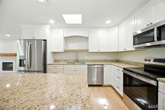 6905 Scenic View Dr, Cedar Hill, MO 63016 - kitchen with stainless steel appliances, a skylight, white cabinets, and recessed lighting