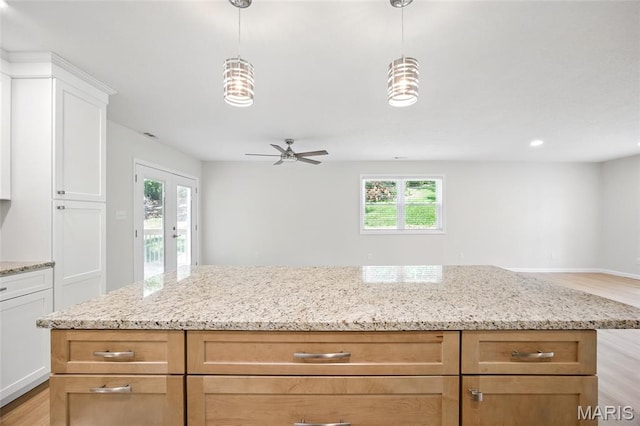 6905 Scenic View Dr, Cedar Hill, MO 63016 - kitchen featuring open floor plan, light stone countertops, light wood-style floors, french doors, and white cabinetry