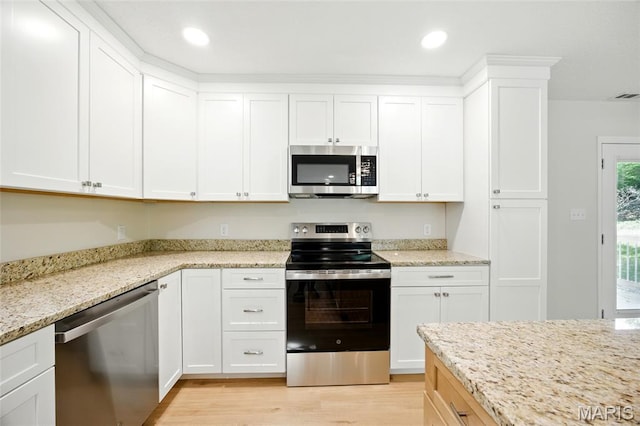 6905 Scenic View Dr, Cedar Hill, MO 63016 - kitchen featuring appliances with stainless steel finishes, light wood-style floors, white cabinets, light stone countertops, and recessed lighting
