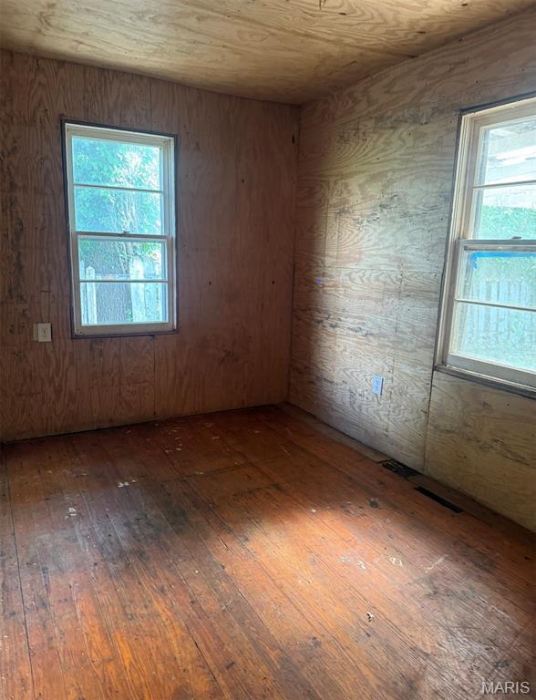 340 S Kitchen St, Dexter, MO 63841 - empty room featuring hardwood / wood-style flooring and wooden walls
