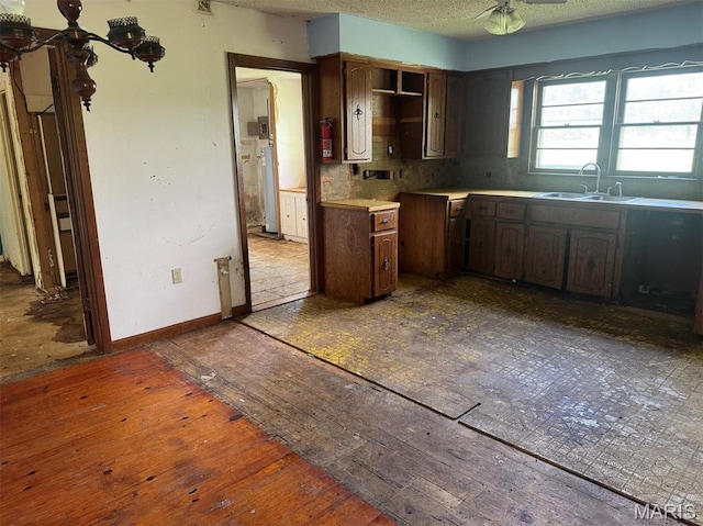 340 S Kitchen St, Dexter, MO 63841 - kitchen featuring wood-type flooring, a textured ceiling, a ceiling fan, gas water heater, and backsplash