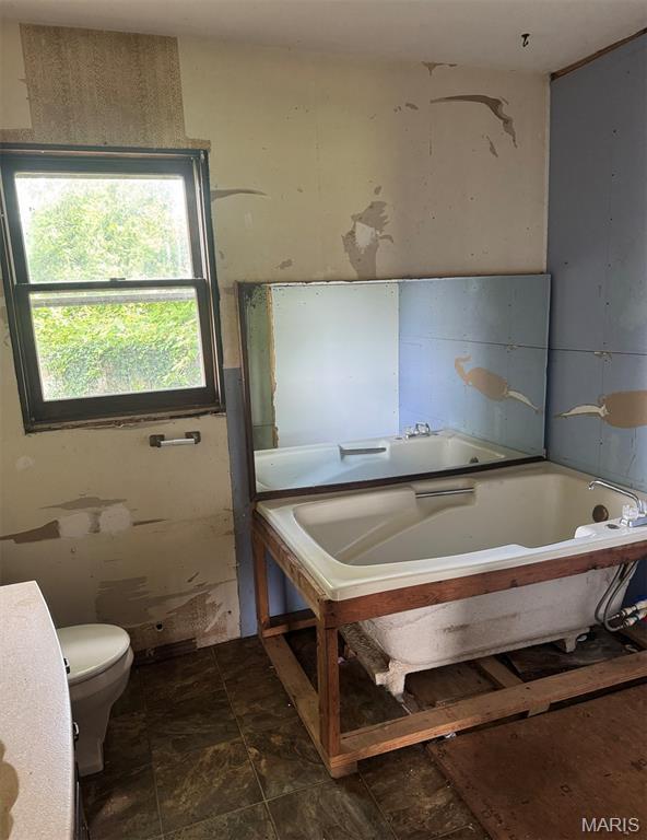 340 S Kitchen St, Dexter, MO 63841 - bathroom with a bath and stone finish flooring