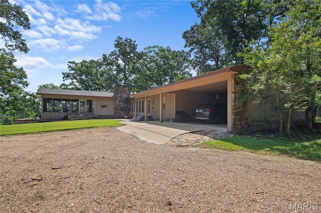 2402 Ripley Rte Unit A, Doniphan, MO 63935 - view of front facade with concrete driveway, a carport, stone siding, a chimney, and a front yard