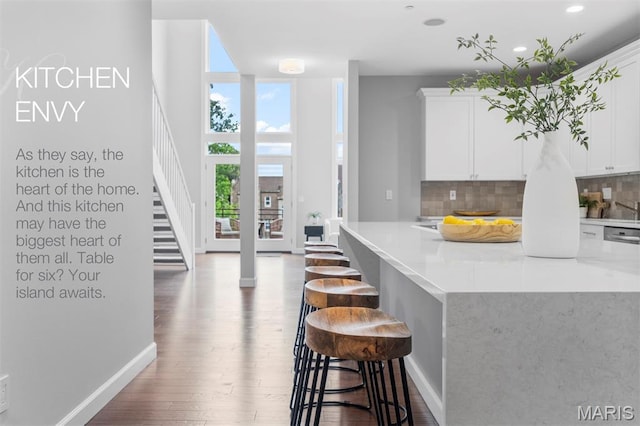 110 N Newstead Ave Unit 303, Saint Louis, MO 63108 - kitchen featuring a breakfast bar area, light countertops, backsplash, white cabinets, and recessed lighting
