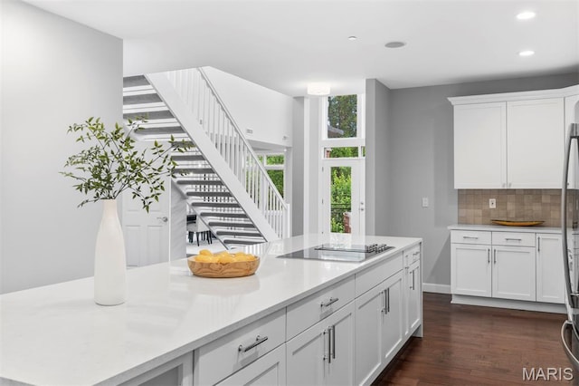 110 N Newstead Ave Unit 303, Saint Louis, MO 63108 - kitchen featuring black electric cooktop, tasteful backsplash, light countertops, white cabinetry, and dark wood finished floors