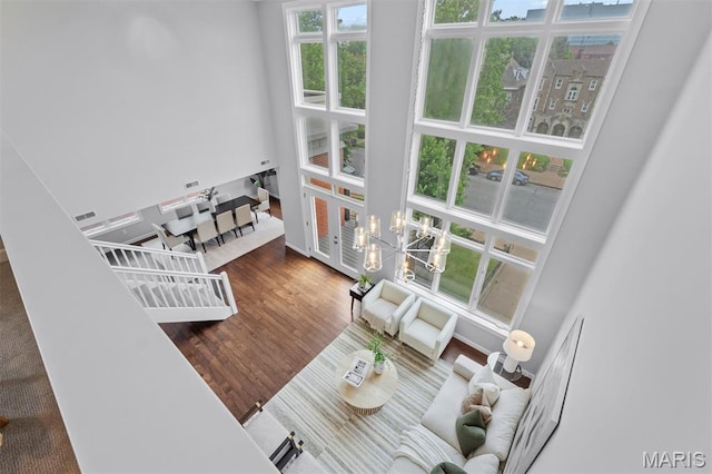 110 N Newstead Ave Unit 303, Saint Louis, MO 63108 - living area featuring a chandelier, wood finished floors, and a towering ceiling