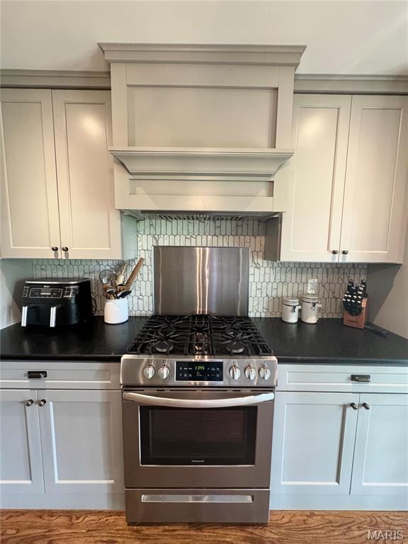 1311 W Line St, Palmyra, MO 63461 - kitchen featuring stainless steel gas stove, dark countertops, tasteful backsplash, custom exhaust hood, and white cabinets