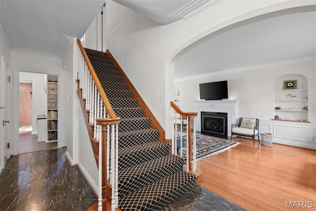 8140 Pershing Ave, Clayton, MO 63105 - stairway featuring ornamental molding, arched walkways, a fireplace, and built in shelves