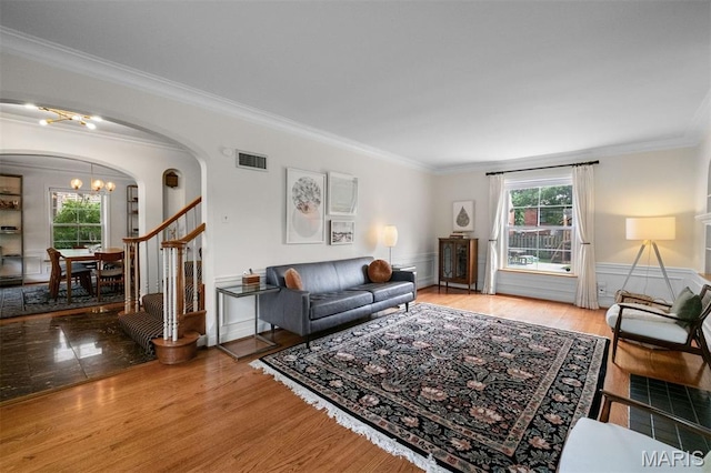 8140 Pershing Ave, Clayton, MO 63105 - living room featuring arched walkways, a chandelier, ornamental molding, plenty of natural light, and a wainscoted wall