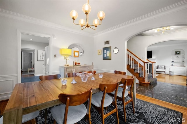 8140 Pershing Ave, Clayton, MO 63105 - dining space with a chandelier, ornamental molding, stairs, wood finished floors, and arched walkways