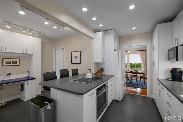 8140 Pershing Ave, Clayton, MO 63105 - kitchen with black appliances, dark countertops, a peninsula, white cabinets, and a kitchen breakfast bar