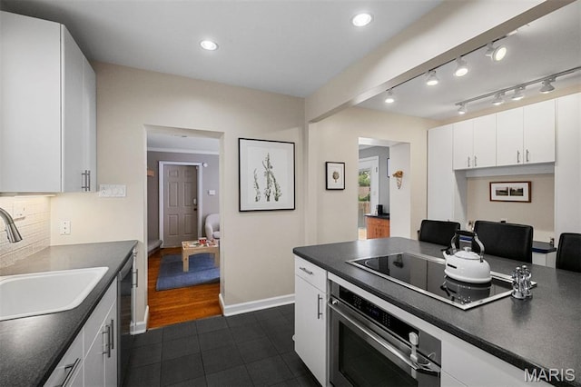8140 Pershing Ave, Clayton, MO 63105 - kitchen with stainless steel appliances, dark countertops, dark tile patterned flooring, white cabinetry, and recessed lighting