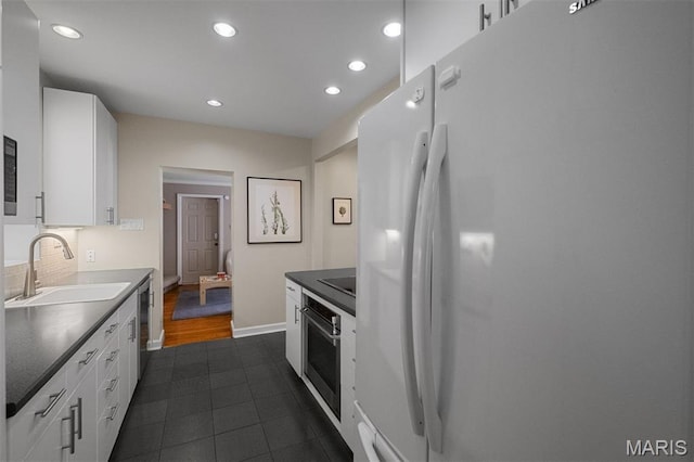 8140 Pershing Ave, Clayton, MO 63105 - kitchen with freestanding refrigerator, stainless steel oven, recessed lighting, white cabinets, and dark countertops