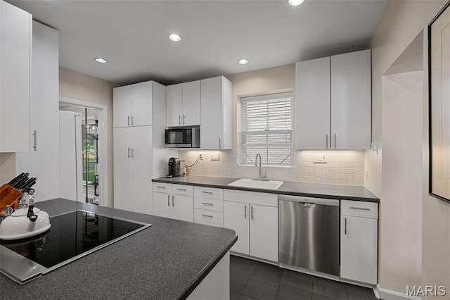 8140 Pershing Ave, Clayton, MO 63105 - kitchen with black appliances, dark countertops, recessed lighting, tasteful backsplash, and white cabinets