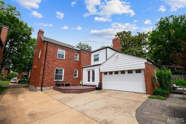 8140 Pershing Ave, Clayton, MO 63105 - view of front of home with a chimney, driveway, brick siding, a garage, and french doors