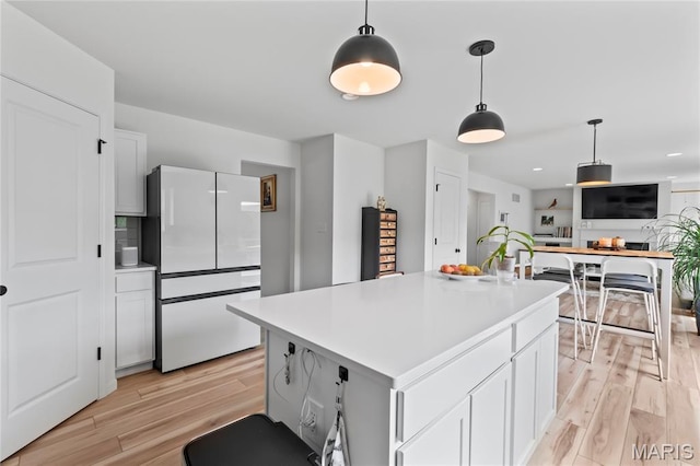 1549 Cascade Ln, Eureka, MO 63025 - kitchen with freestanding refrigerator, light wood-style flooring, light countertops, and pendant lighting