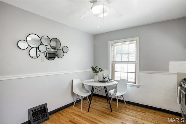 7041 Plainview Ave, Saint Louis, MO 63109 - dining area featuring light wood-style floors, a ceiling fan, and wainscoting