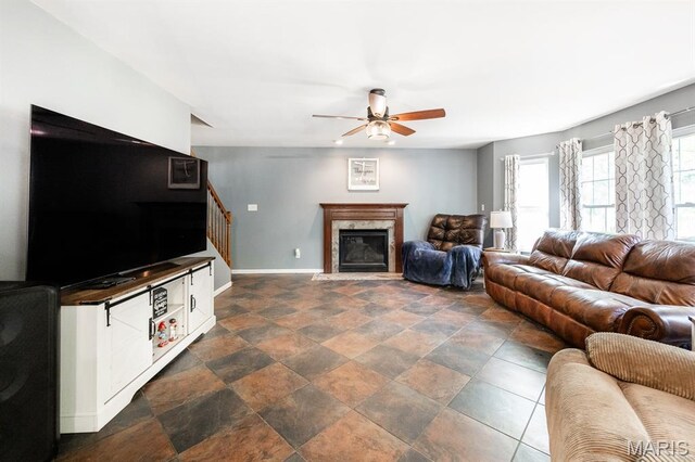 1241 Antique Ln, Mascoutah, IL 62258 - living area featuring stairs, a ceiling fan, a premium fireplace, and dark stone finish floors