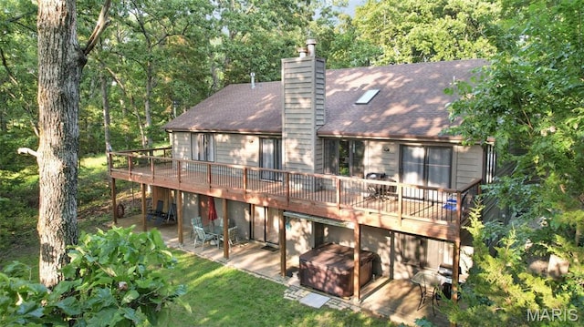 877 Red Fox Dr, Innsbrook, MO 63390 - back of house featuring a patio, a wooden deck, a chimney, a shingled roof, and a lawn