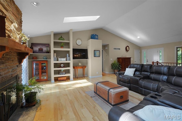 877 Red Fox Dr, Innsbrook, MO 63390 - living room with a skylight, light wood-type flooring, vaulted ceiling, a fireplace, and recessed lighting