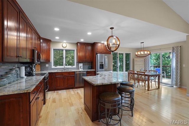 877 Red Fox Dr, Innsbrook, MO 63390 - kitchen with appliances with stainless steel finishes, light wood finished floors, backsplash, a chandelier, and plenty of natural light