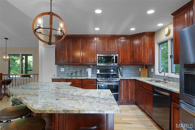 877 Red Fox Dr, Innsbrook, MO 63390 - kitchen featuring appliances with stainless steel finishes, a chandelier, light wood-style floors, light stone countertops, and recessed lighting
