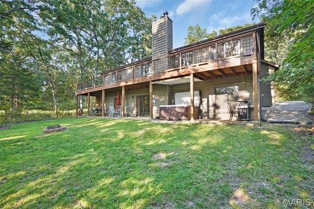 877 Red Fox Dr, Innsbrook, MO 63390 - back of house featuring an outdoor fire pit, a jacuzzi, a wooden deck, a chimney, and a lawn