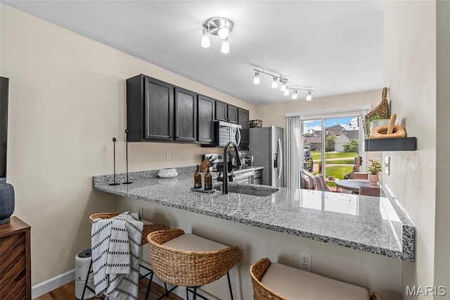 847 Boardwalk Springs Pl, Ofallon, MO 63368 - kitchen featuring stainless steel appliances, light stone countertops, a peninsula, and a breakfast bar