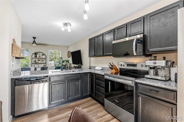 847 Boardwalk Springs Pl, Ofallon, MO 63368 - kitchen featuring stainless steel appliances, light wood-style floors, ceiling fan, and light stone countertops