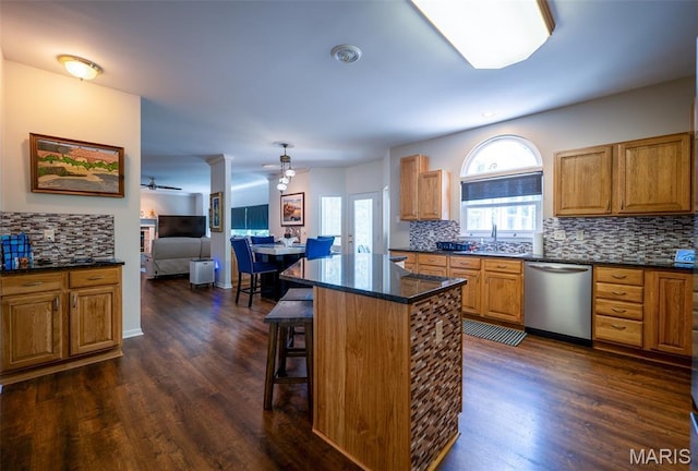 824 Legends View Dr, Eureka, MO 63025 - kitchen with stainless steel dishwasher, ceiling fan, backsplash, dark wood-style flooring, and a kitchen breakfast bar