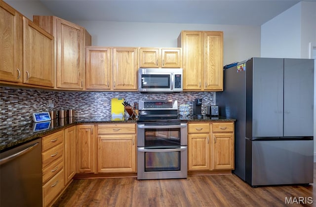 824 Legends View Dr, Eureka, MO 63025 - kitchen with stainless steel appliances, dark wood-type flooring, decorative backsplash, and dark stone counters