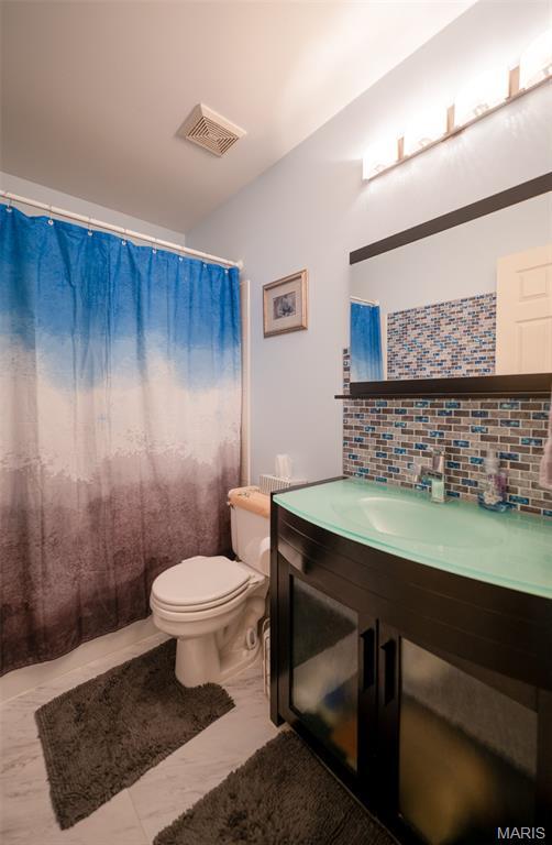 824 Legends View Dr, Eureka, MO 63025 - bathroom with backsplash, vanity, marble look tiles, and a shower with curtain