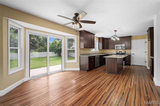 8 Dugout Ct, Ofallon, MO 63366 - kitchen featuring stainless steel appliances, dark brown cabinetry, a center island, dark wood finished floors, and plenty of natural light