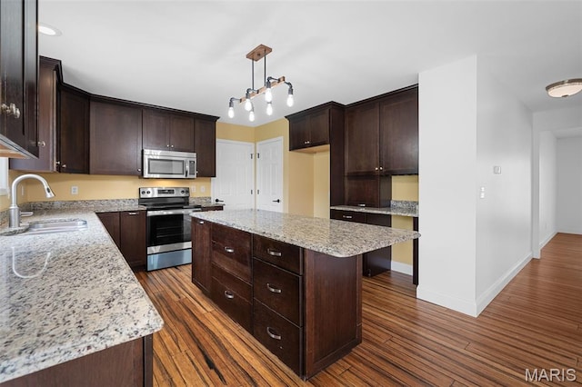 8 Dugout Ct, Ofallon, MO 63366 - kitchen with appliances with stainless steel finishes, dark brown cabinetry, dark wood-type flooring, and a kitchen island