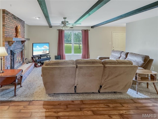4423 Project Rd, Luebbering, MO 63061 - living area featuring wood-type flooring, beamed ceiling, a fireplace, and a ceiling fan