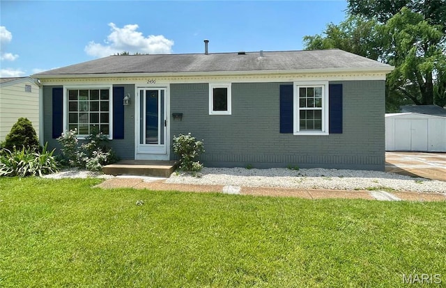 2490 Mullanphy Ln, Florissant, MO 63031 - view of front facade with a shed, a front yard, and brick siding