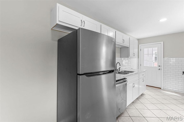 2490 Mullanphy Ln, Florissant, MO 63031 - kitchen with stainless steel appliances, white cabinetry, light tile patterned floors, and light countertops