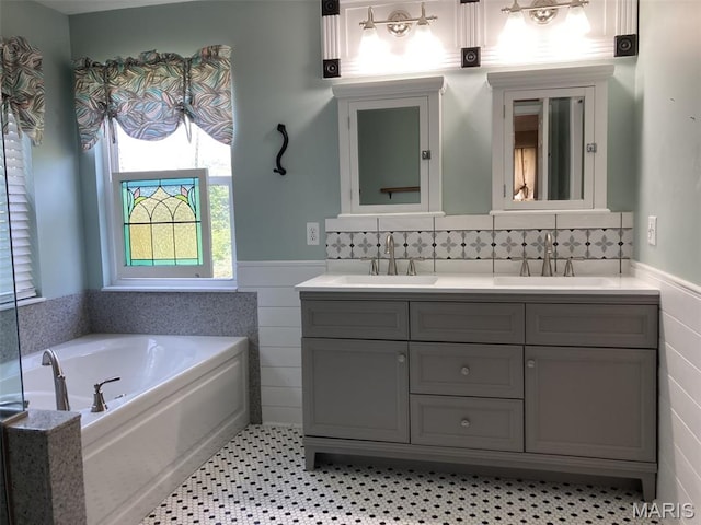 225 Country Crest Ln, Union, MO 63084 - bathroom with double vanity, tile walls, wainscoting, and a garden tub