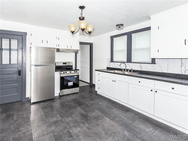 530 Poplar St, Highland, IL 62249 - kitchen featuring appliances with stainless steel finishes, range hood, dark countertops, and white cabinetry