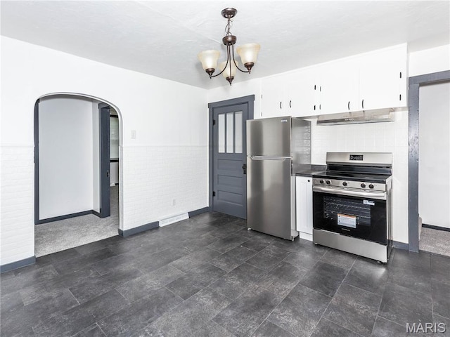 530 Poplar St, Highland, IL 62249 - kitchen featuring appliances with stainless steel finishes, range hood, white cabinets, arched walkways, and hanging light fixtures